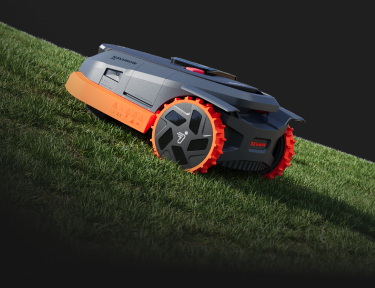 Navimow i110E robot lawn mower on a steep grassy slope.