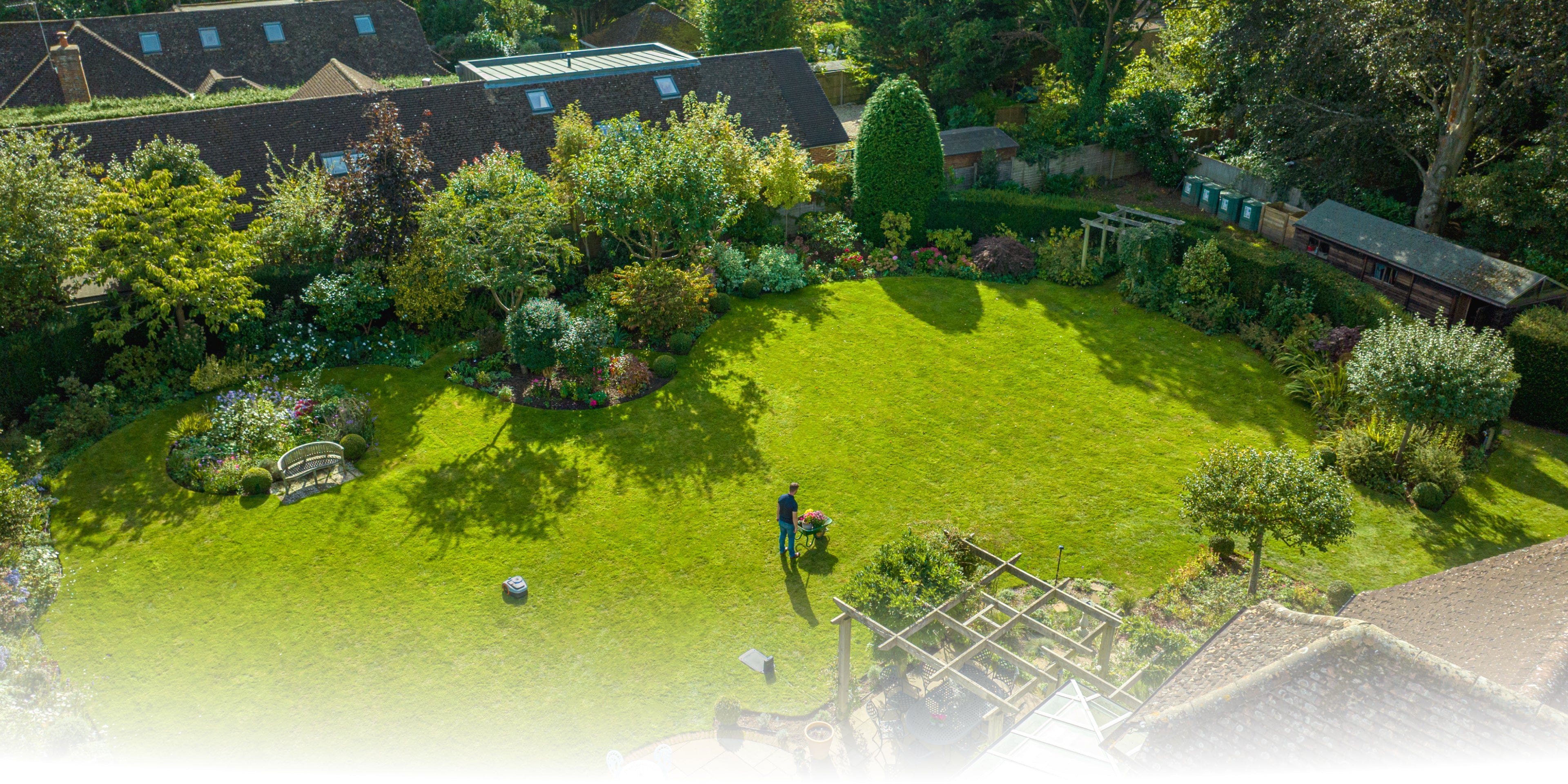 Navimow i110E robot lawn mower in a lush green garden.