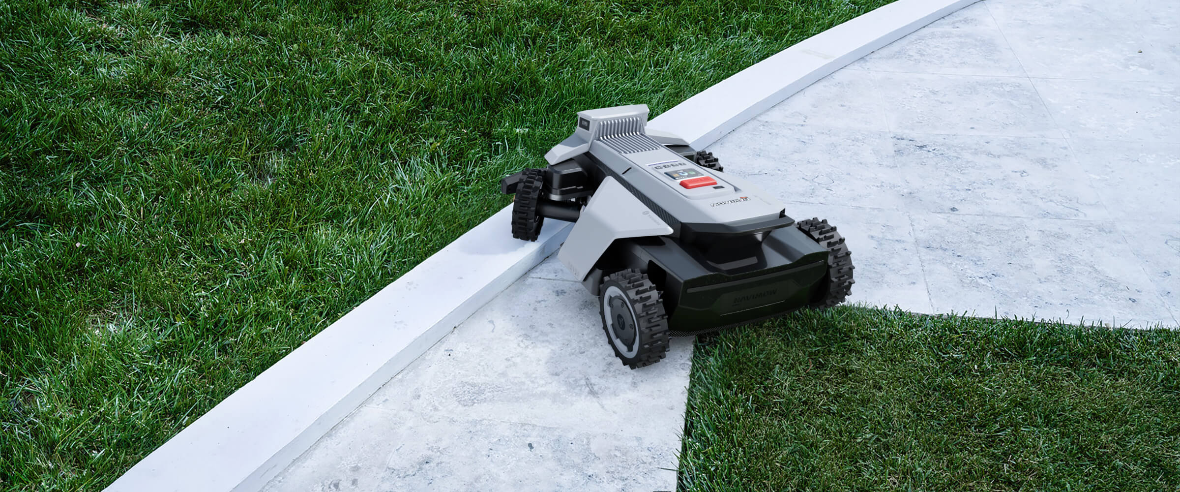 Navimow i110E robot lawn mower moving across a stone path.