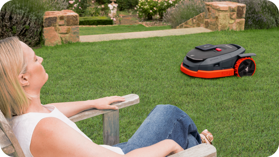 Segway Navimow i Series robot lawn mower mows while woman relaxes.