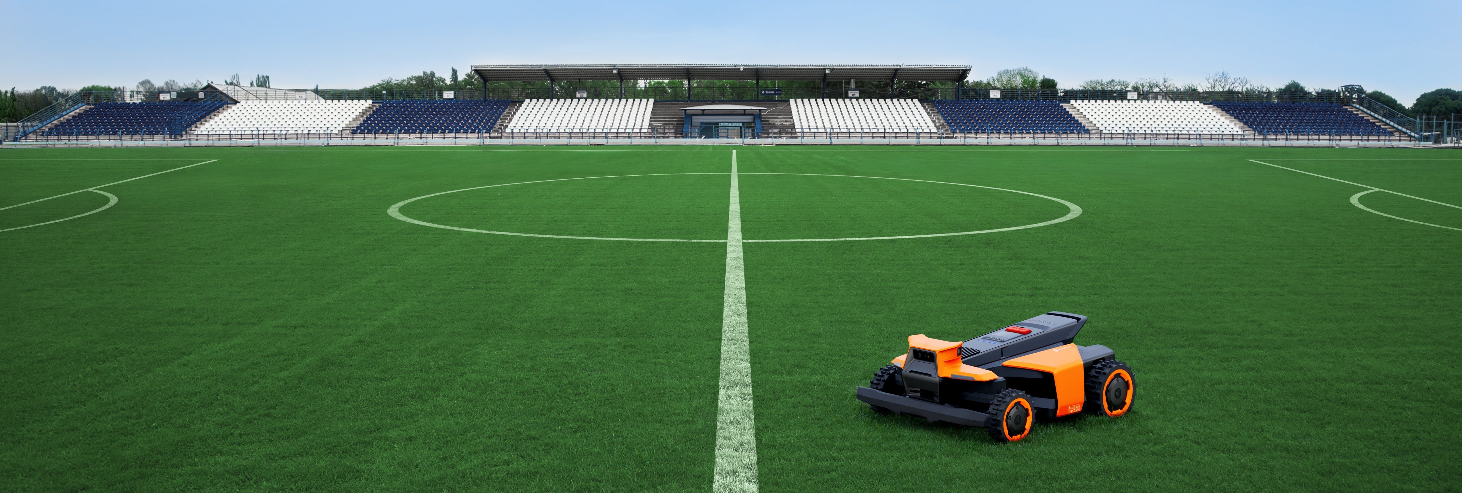 Navimow i110E robot lawn mower on a green football pitch.