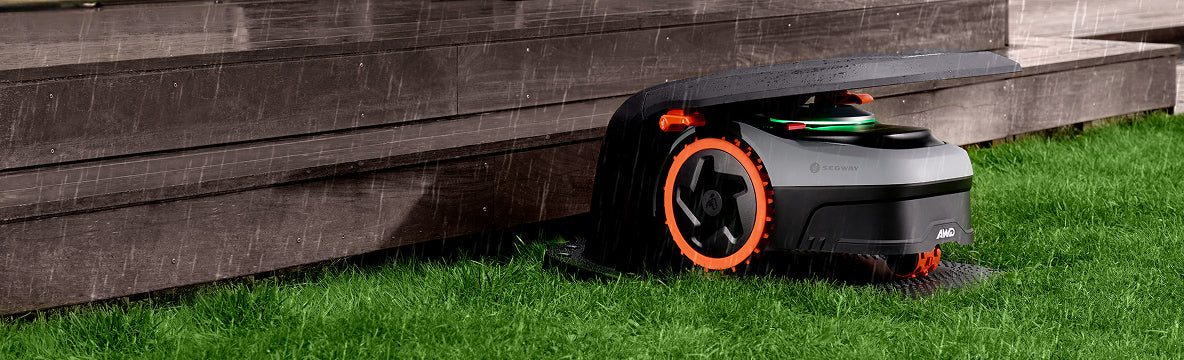 Navimow i Series robot lawn mower sits under rain cover.