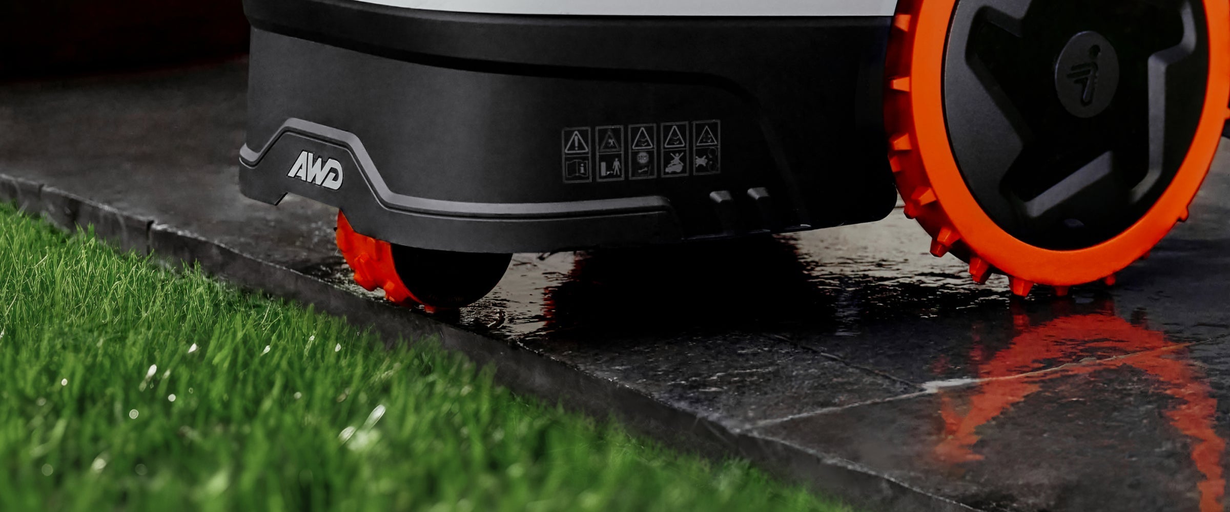 Segway Navimow i105E robot lawn mower on wet stone pavement.